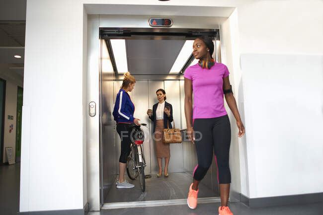 Female colleagues taking office lift — Stock Photo