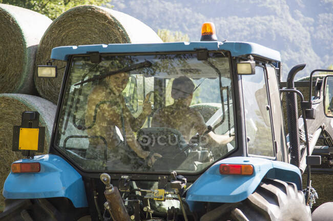 Recogida de tractores apilando pajar circular - foto de stock