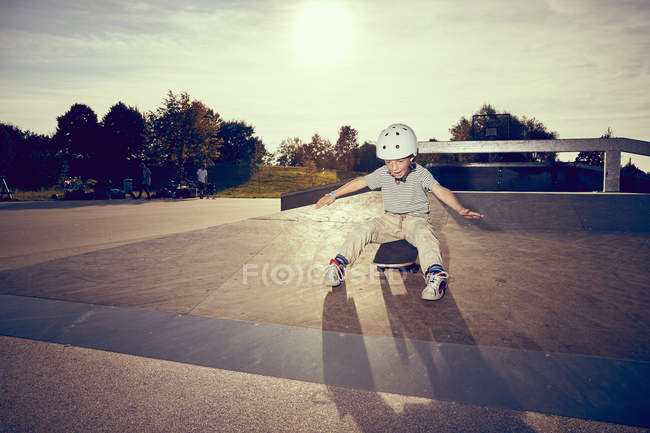 Bambino in casco skateboard nel parco — Foto stock