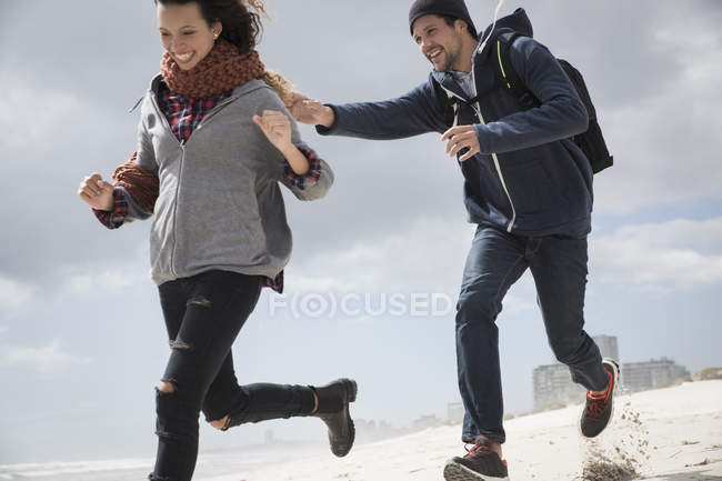 Young couple running and chasing on beach, Western Cape, South Africa — Stock Photo