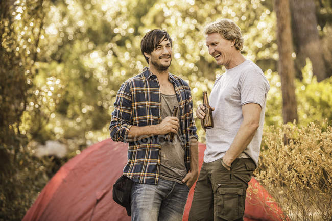 Two male campers chatting  and drinking beer in forest, Deer Park, Cape Town, South Africa — Stock Photo