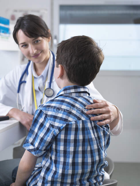 Doctor consulting with boy — Stock Photo