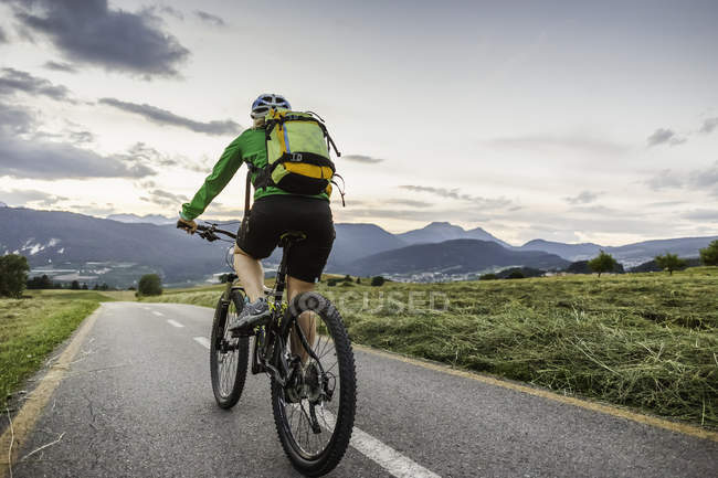 Donna in bicicletta su strada, Fondo, Trentino, Italia — Foto stock