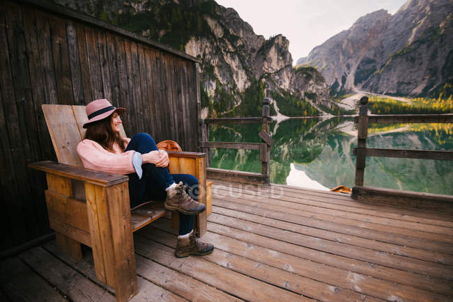 Woman relaxing on wooden chair, Lago di Braies, Dolomite Alps, Val di Braies, South Tyrol, Italy — Stock Photo