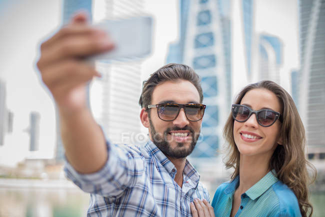 Pareja de turistas tomando selfie smartphone, Dubai, Emiratos Árabes Unidos - foto de stock
