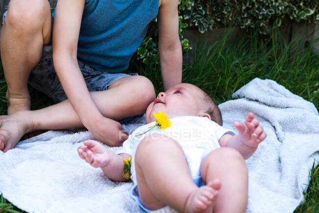 Schnittwunden an Baby, das Bruder im Garten anstarrt — Stockfoto