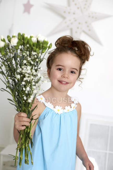 Girl with carnations against white wall with stars — Stock Photo