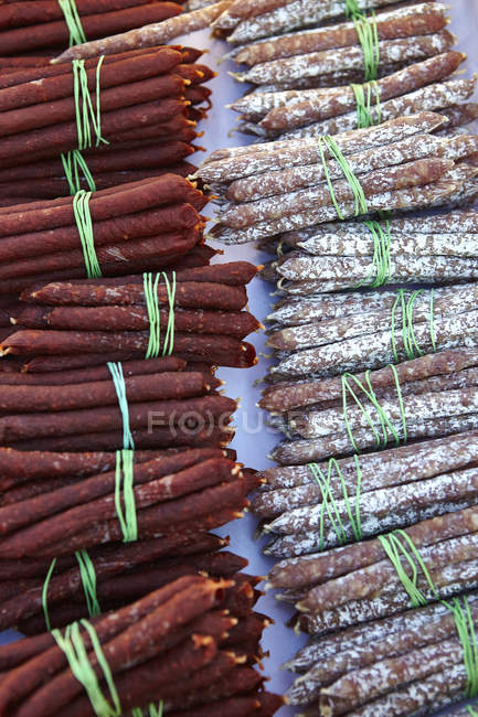 Bundles and rows of saucisson on market stall, St Tropez, Costa Azul, Francia - foto de stock