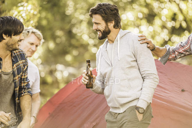 Four men drinking beer whilst camping  in forest, Deer Park, Cape Town, South Africa — Stock Photo