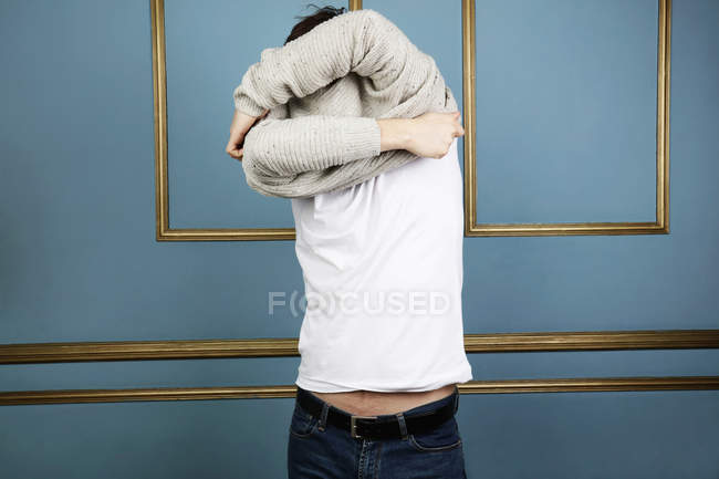 Mittlerer erwachsener Mann zieht Pullover aus — Stockfoto