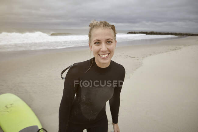 Retrato de una joven surfista en Rockaway Beach, Nueva York, EE.UU. - foto de stock