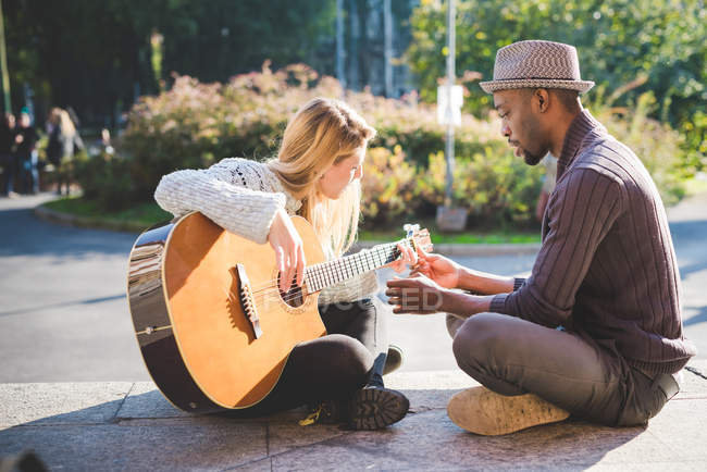 Пара вчиться грати на гітарі в парку — стокове фото