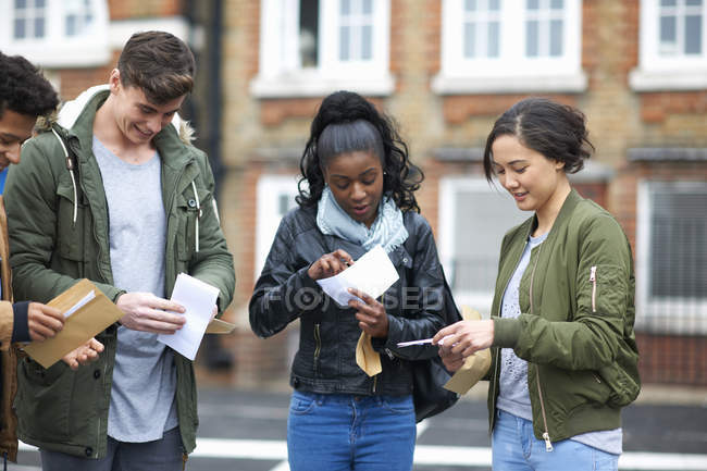 Молодих дорослих студентів читання результати іспиту на кампусі — стокове фото