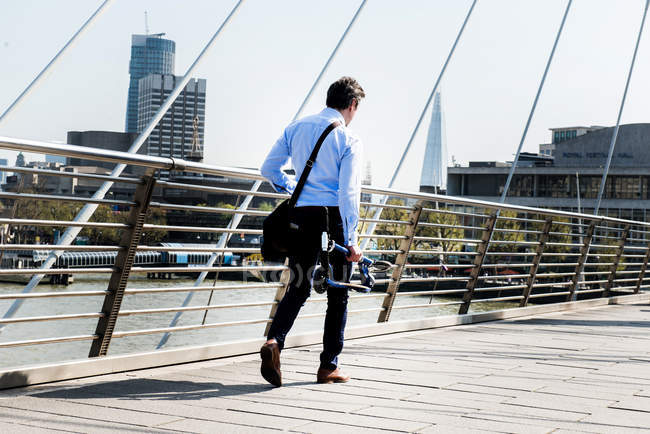 Бизнесмен с мотороллером на Венгерфордском мосту, Лондон, Великобритания — стоковое фото