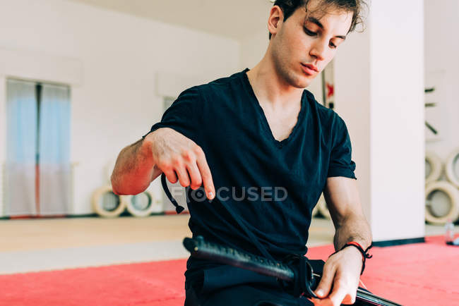 Artista marcial em ginásio preparando espada — Fotografia de Stock