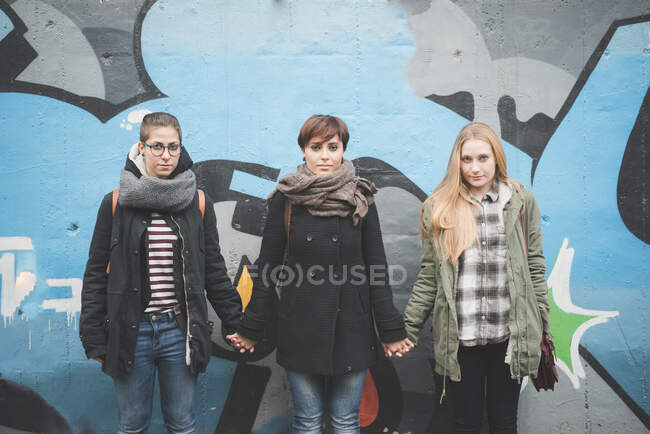 Три сестри за графіті стіни — стокове фото