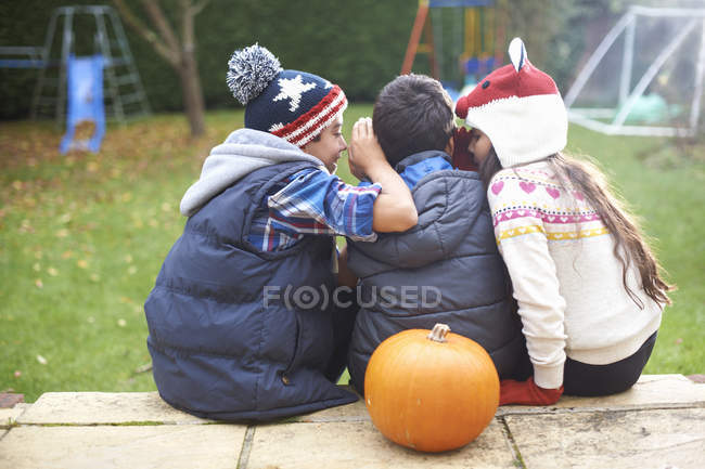 Siblings sitting on steps in garden at home — Stock Photo