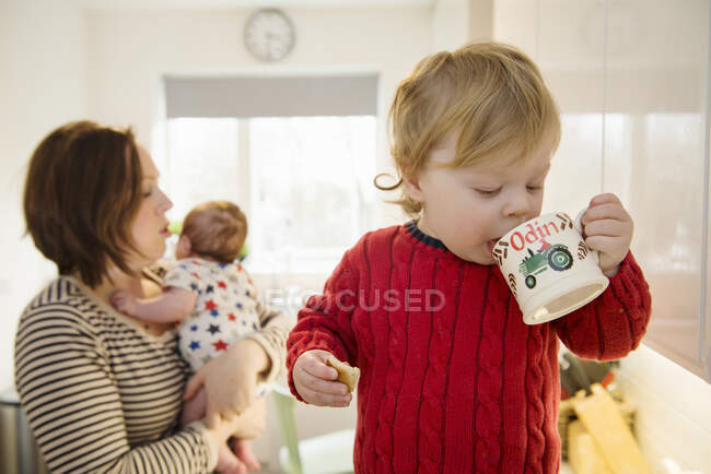 Хлопчик п'є з чашки — стокове фото