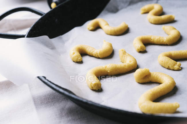 Wavy shaped pastry on baking paper — Stock Photo