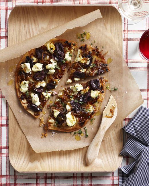 Karamellisierte Zwiebelpizza auf Schneidebrett — Stockfoto
