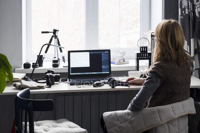 Mitte erwachsene Frau sitzt am Schreibtisch, benutzt Computer, Rückansicht — Stockfoto
