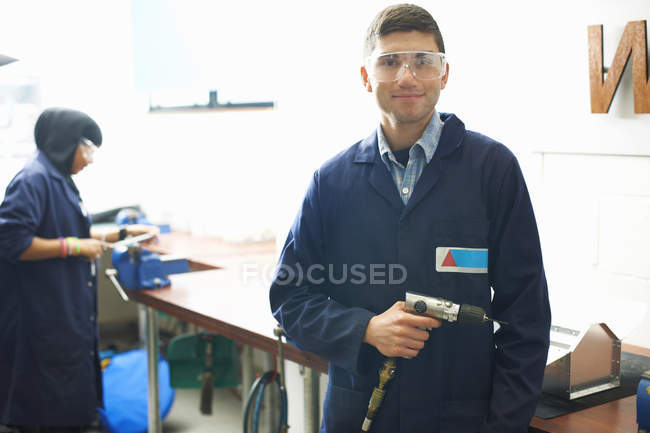 Ritratto di studente maschio con trapano a mano nel laboratorio di metallurgia del college — Foto stock