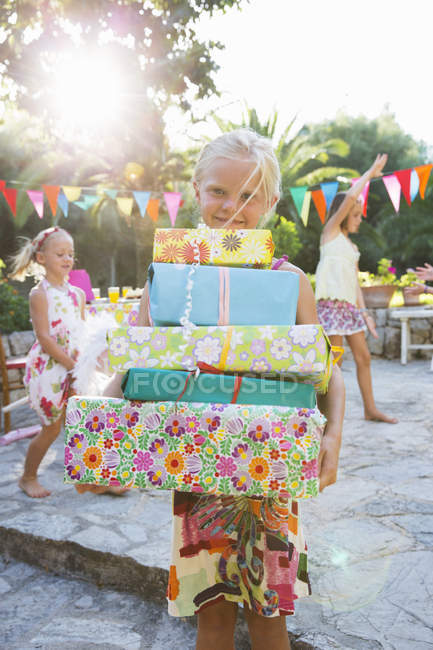 Menina com pilha de presentes de aniversário na festa com amigos — Fotografia de Stock