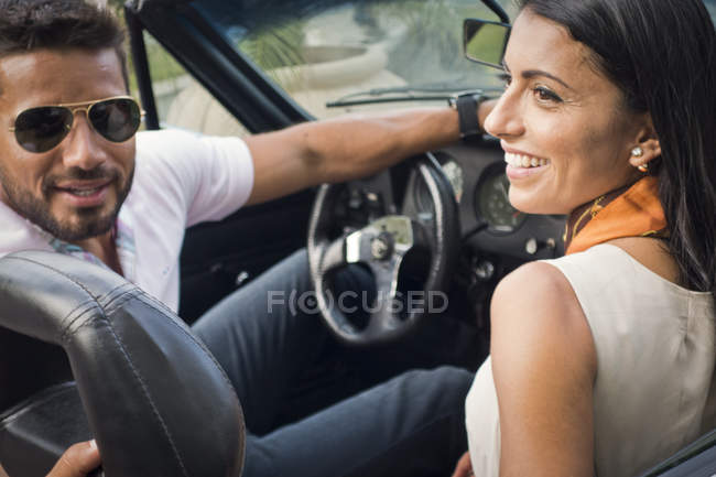 Mid adult couple in convertible car, rear view — Stock Photo