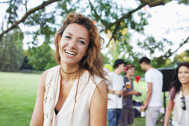 Portrait of happy young woman at sunset party in park — Stock Photo