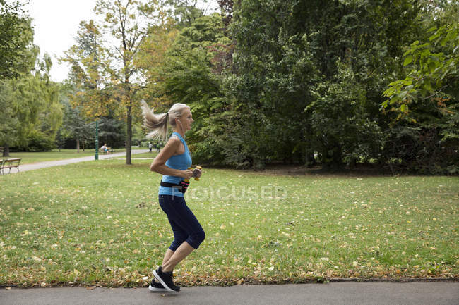 Зрелая бегунья бегает в парке — стоковое фото