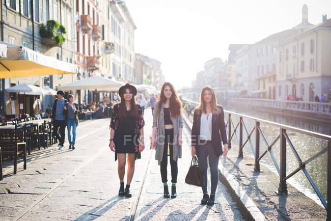 Portrait de trois jeunes femmes élégantes sur le front de mer du canal — Photo de stock