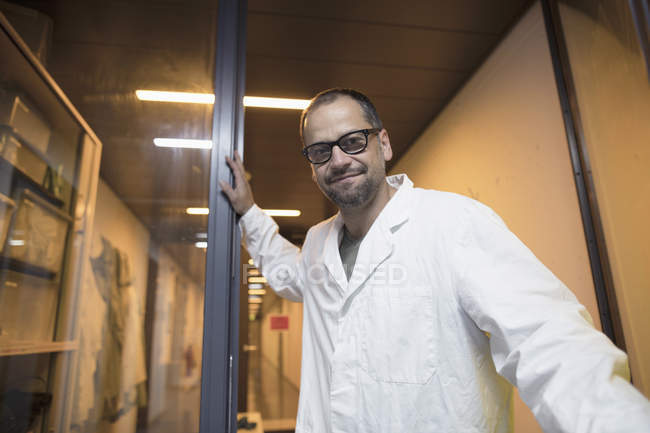 Лабораторний помічник стоїть біля скляних дверей — стокове фото