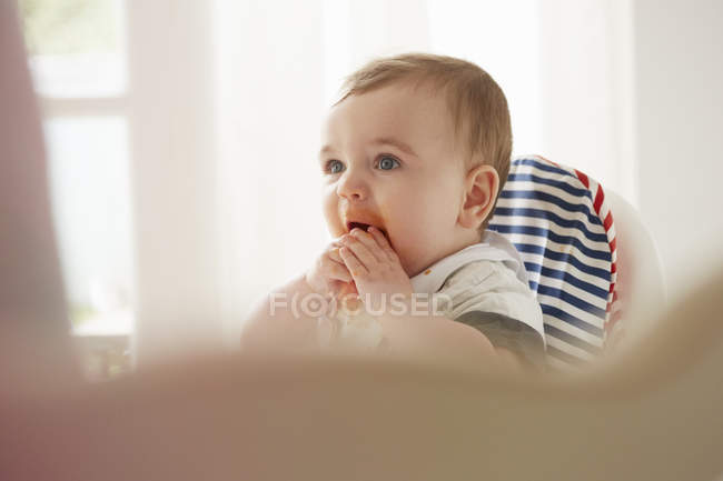 Bambino ragazzo alimentando se stesso in sedia bambino — Foto stock