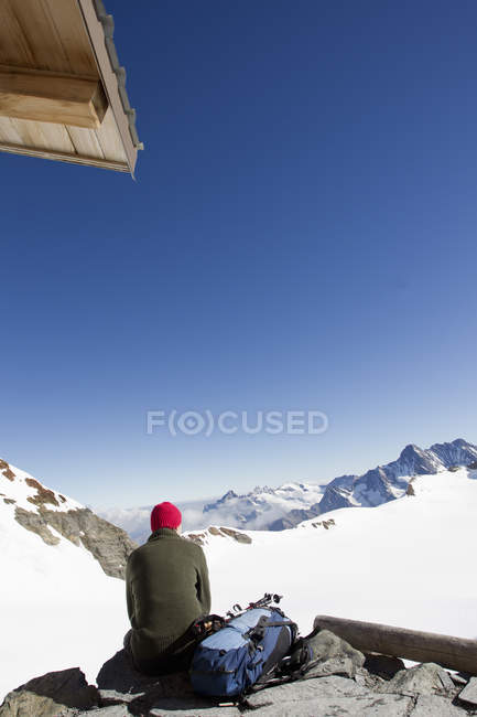 Задній вид чоловічого мандрівного, дивлячись краєвид з оглядового майданчика, Jungfrauchjoch, висоті, Швейцарія — стокове фото