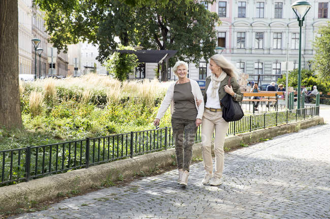 Mutter und Tochter gehen gemeinsam die Straße entlang — Stockfoto