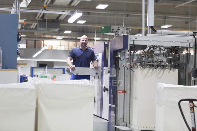 Travailleur utilisant une machine dans une usine d'emballage de papier — Photo de stock
