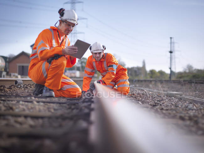 Travailleurs d'entretien ferroviaire utilisant une tablette numérique pour inspecter la voie à Loughborough, Angleterre, Royaume-Uni — Photo de stock