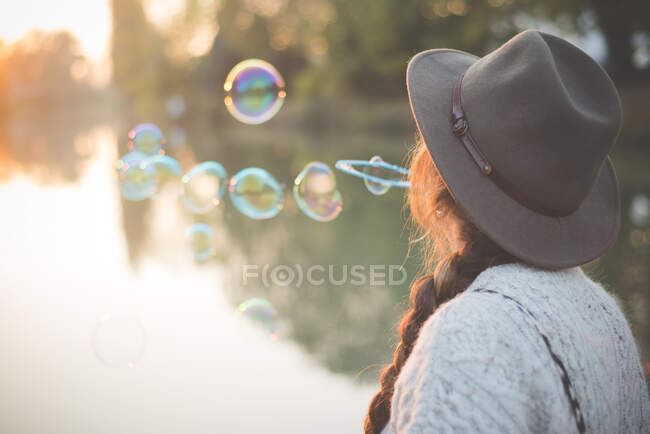 Jeune femme soufflant des bulles — Photo de stock