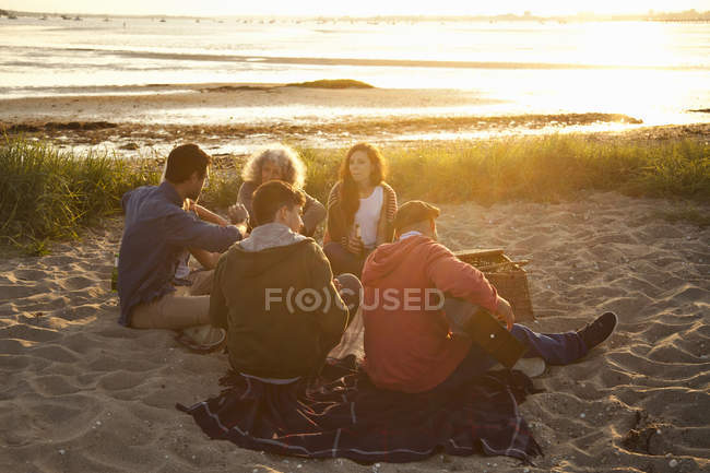 Pique-nique de jeunes amis au coucher du soleil sur la plage de Bournemouth, Dorset, Royaume-Uni — Photo de stock