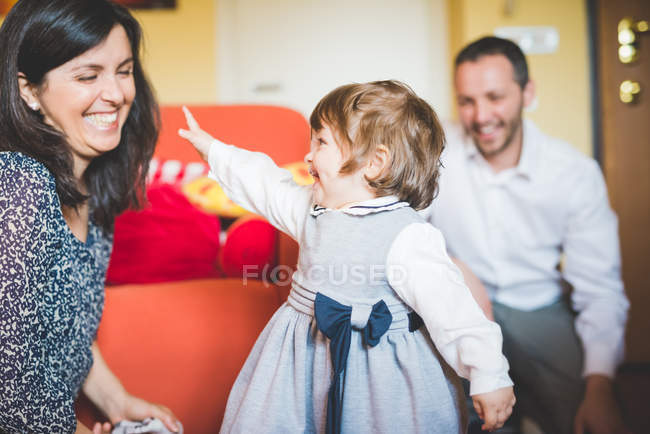 Coppia che gioca con la figlia del bambino in soggiorno — Foto stock