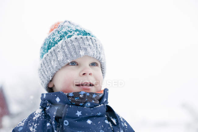 Toddler boy standing in snowy countryside field — Stock Photo