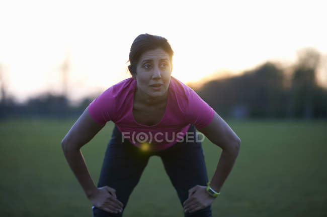 Mature woman taking a break from exercise in park — Stock Photo