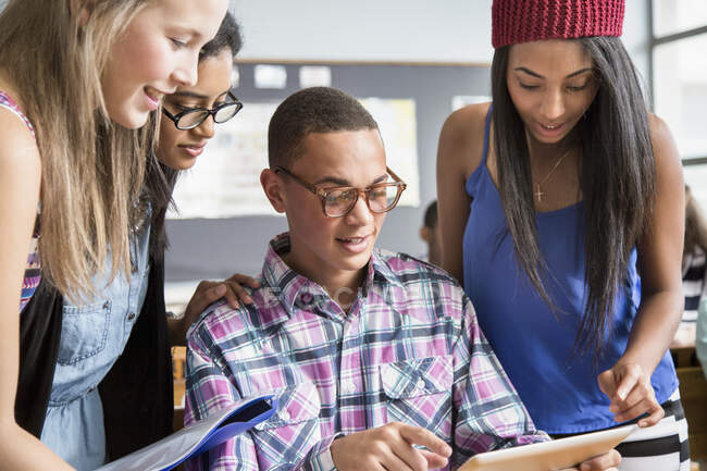 Group of students in classroom, looking at digital tablet — Stock Photo
