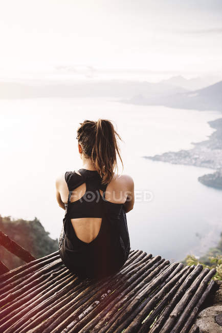 Visão traseira da jovem mulher na varanda com vista para o Lago Atitlan — Fotografia de Stock