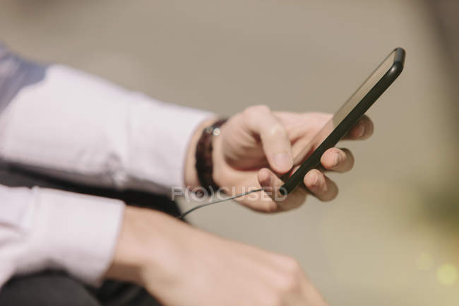 Primer plano plano de la mano masculina utilizando el teléfono inteligente - foto de stock