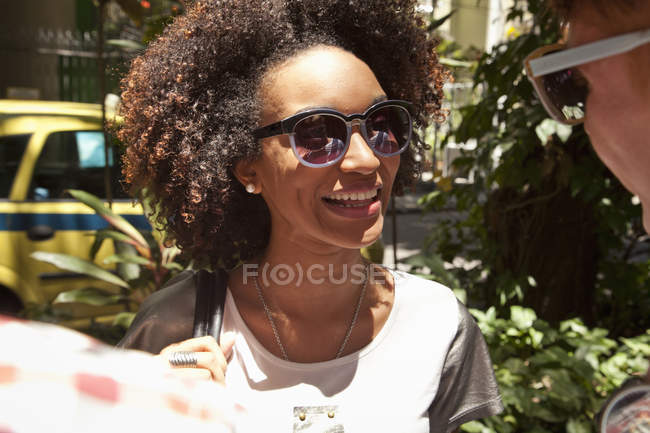 Mujer joven con gafas de sol, sonriendo - foto de stock