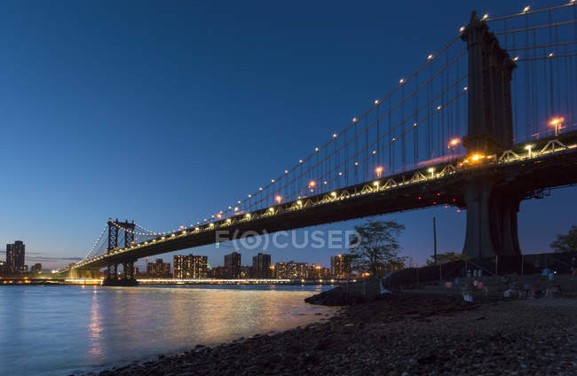 Manhattan bridge from riverbank at night, New York, USA — Stock Photo