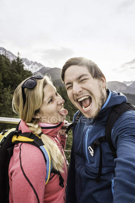 Pareja de senderismo joven posando para selfie en las montañas, Reutte, Tirol, Austria - foto de stock