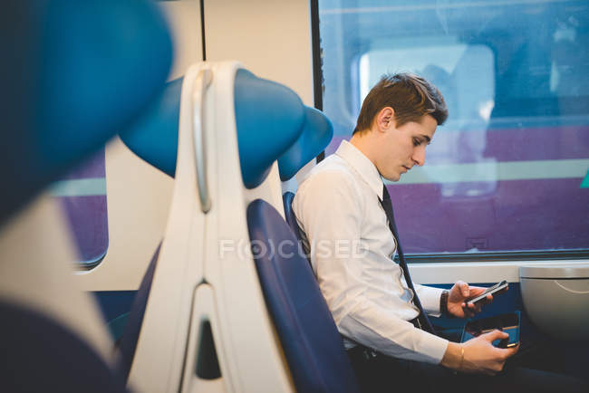Retrato de jovem empresário viajante usando tablet digital no trem . — Fotografia de Stock