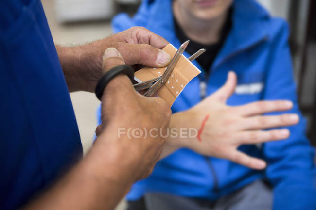 Factory worker applying first aid to colleague — Stock Photo